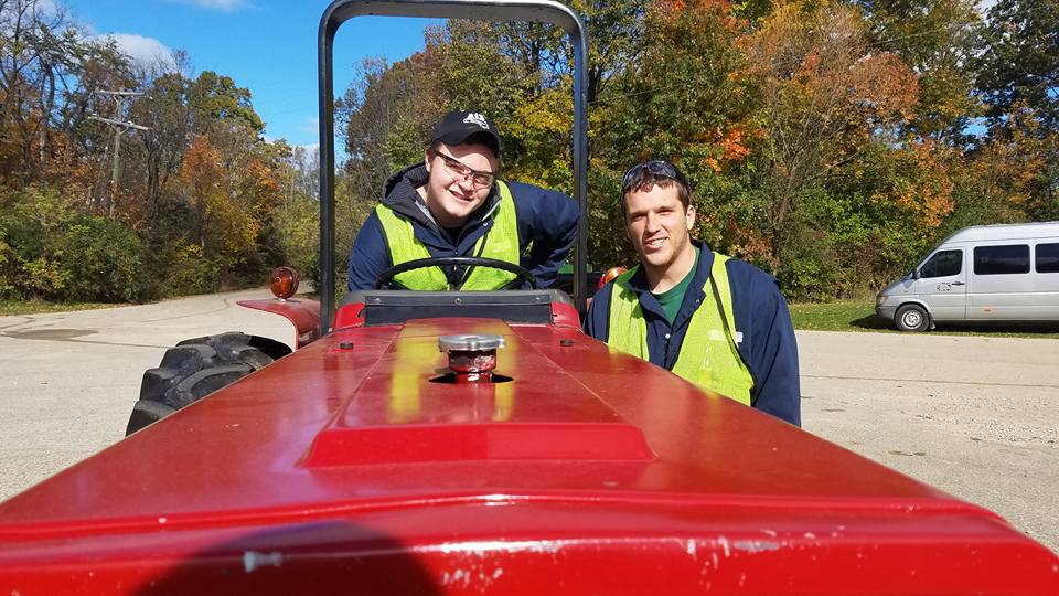 2 students posing for picture during operation of our Case 485 Tractor.