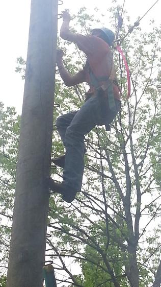 Brett climbs the pole during our high ropes adventure.