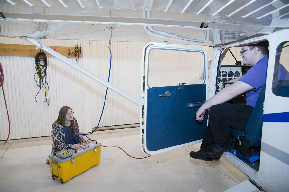 students using test equipment to check airplane