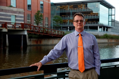 This is a picture of the instructor, Larry Ridley, in front of the river and industrial buildings in Lansing, Michigan