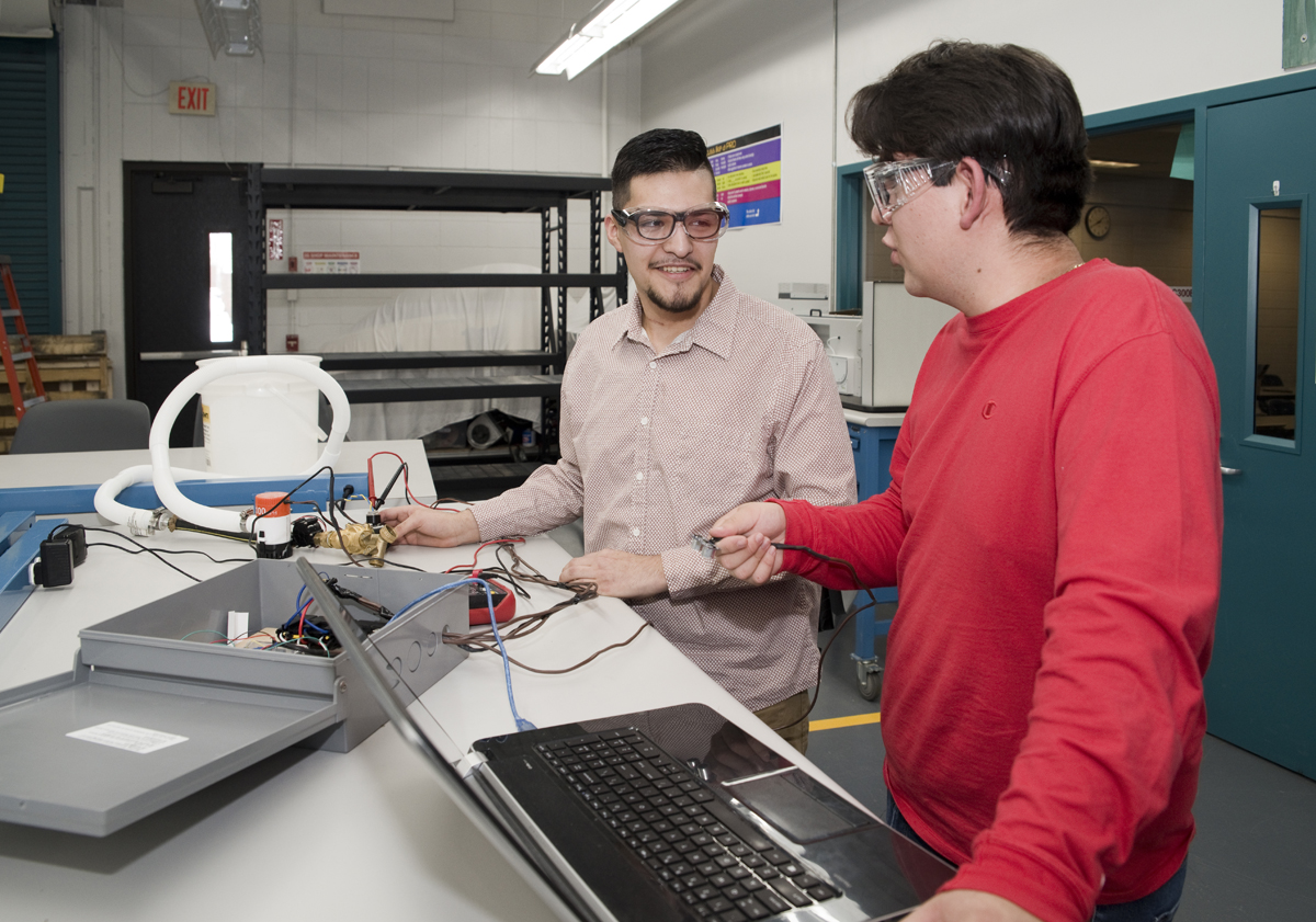 Students working on an electrical project together with a computer.